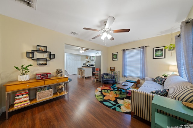 living room featuring visible vents, ceiling fan, and wood finished floors