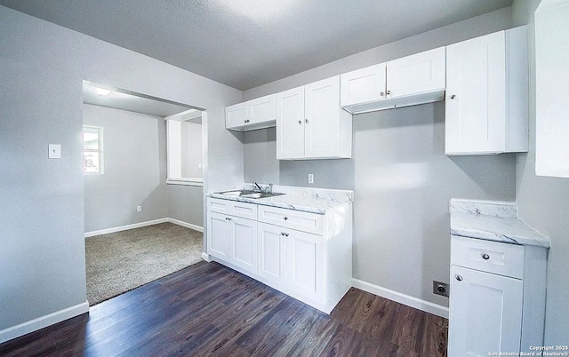 204 Division, San Antonio, TX 78214 - kitchen with baseboards, a sink, dark wood-style flooring, and white cabinetry