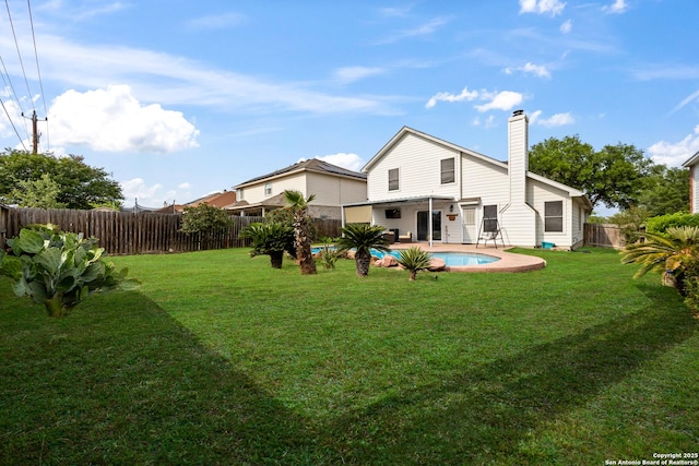 5211 Wood Gln, San Antonio, TX 78244 - back of house with a fenced in pool, a fenced backyard, a yard, and a chimney