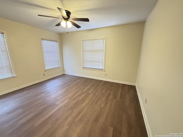 unfurnished room featuring baseboards, a ceiling fan, and dark wood-style floors