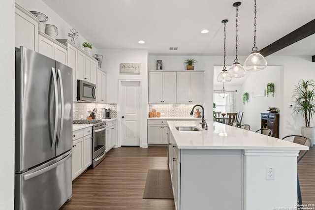 kitchen with light countertops, a sink, tasteful backsplash, and stainless steel appliances
