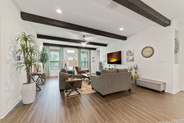 living room with beamed ceiling, baseboards, visible vents, and wood finished floors