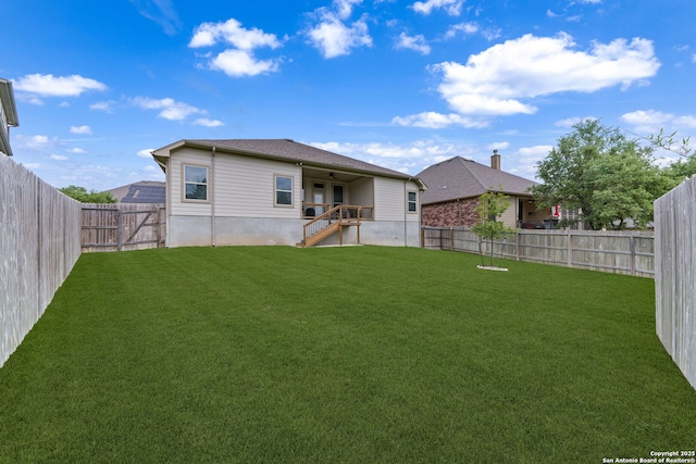 rear view of property with a fenced backyard, stairs, and a lawn