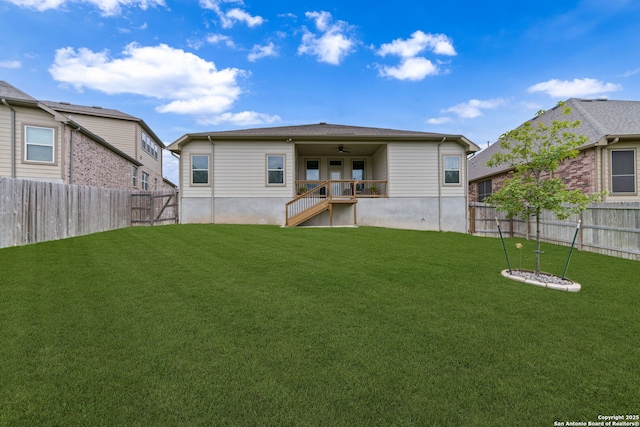 back of property featuring a lawn, ceiling fan, and a fenced backyard