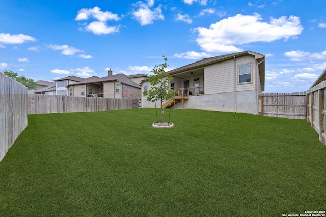 view of yard featuring a fenced backyard and ceiling fan