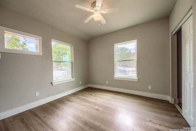 unfurnished bedroom featuring a closet, baseboards, a ceiling fan, and light wood-style floors
