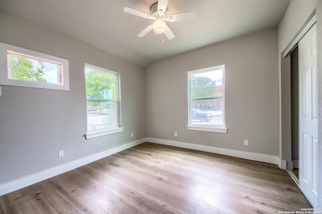 unfurnished bedroom featuring baseboards, a ceiling fan, light wood finished floors, and a closet