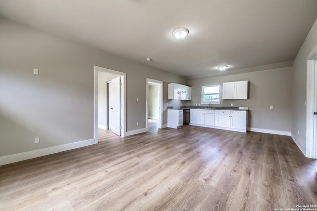 unfurnished living room featuring baseboards and light wood-style floors