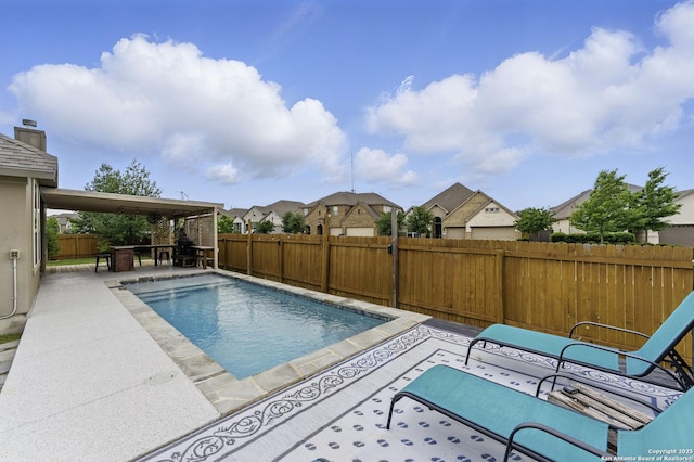 view of swimming pool with a fenced in pool, a residential view, a fenced backyard, and a patio area