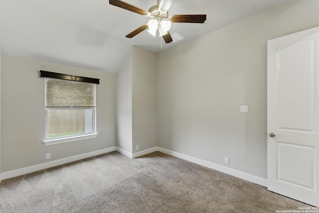 spare room featuring carpet flooring, ceiling fan, vaulted ceiling, and baseboards