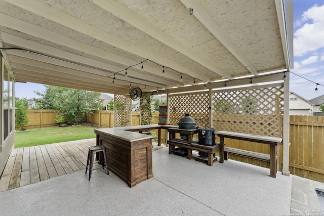 view of patio with grilling area, a wooden deck, and a fenced backyard