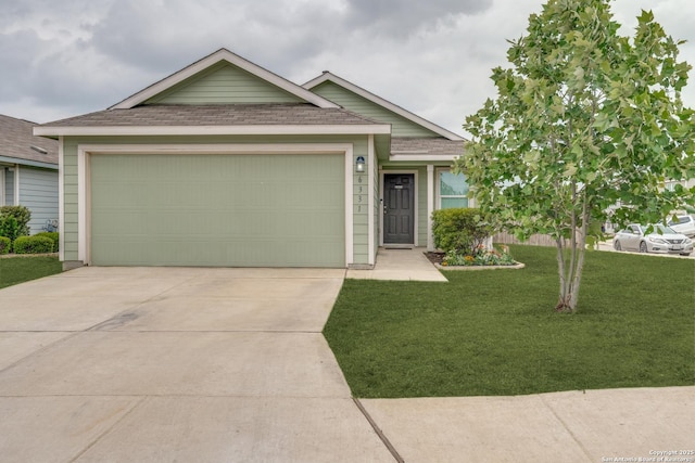 ranch-style home featuring concrete driveway, a garage, roof with shingles, and a front lawn