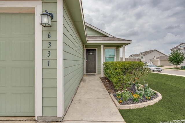 view of exterior entry with a lawn