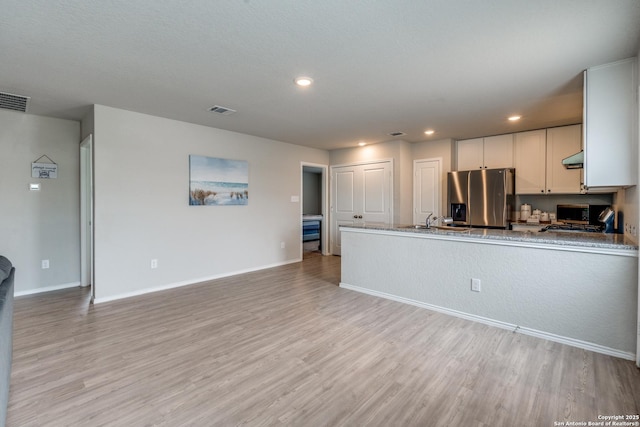 kitchen featuring recessed lighting, stainless steel fridge with ice dispenser, light wood finished floors, and visible vents