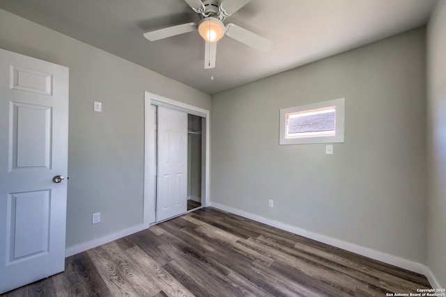 unfurnished bedroom with baseboards, ceiling fan, dark wood-style floors, and a closet