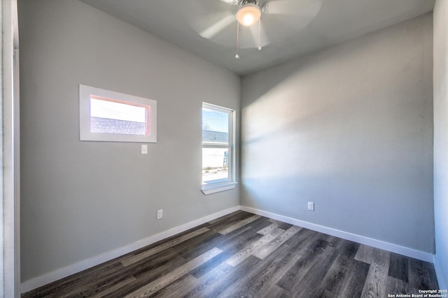unfurnished room with baseboards, a ceiling fan, and dark wood-style flooring