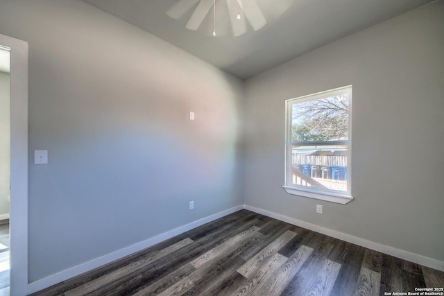 empty room with baseboards, ceiling fan, and dark wood-style floors
