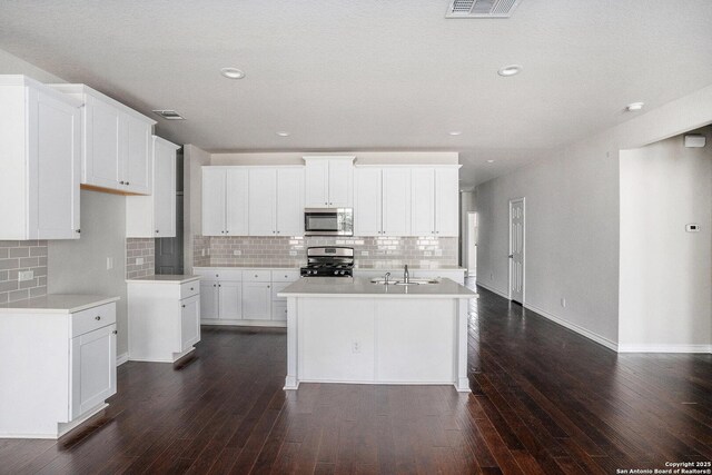 12448 Big Valley Crk, San Antonio, TX 78254 - kitchen featuring appliances with stainless steel finishes, backsplash, and dark wood-style flooring