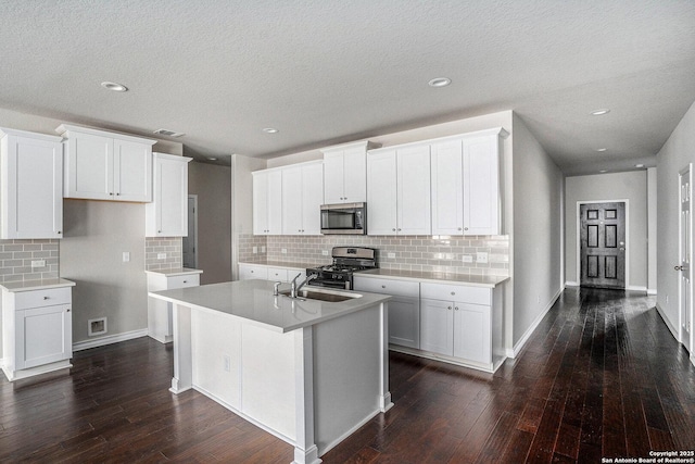 12448 Big Valley Crk, San Antonio, TX 78254 - kitchen with decorative backsplash, visible vents, a sink, stainless steel appliances, and dark wood-type flooring
