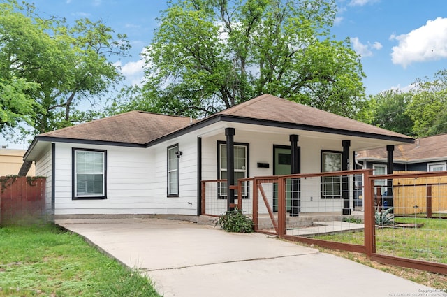 view of front of property featuring fence, a shingled roof, a porch, and driveway