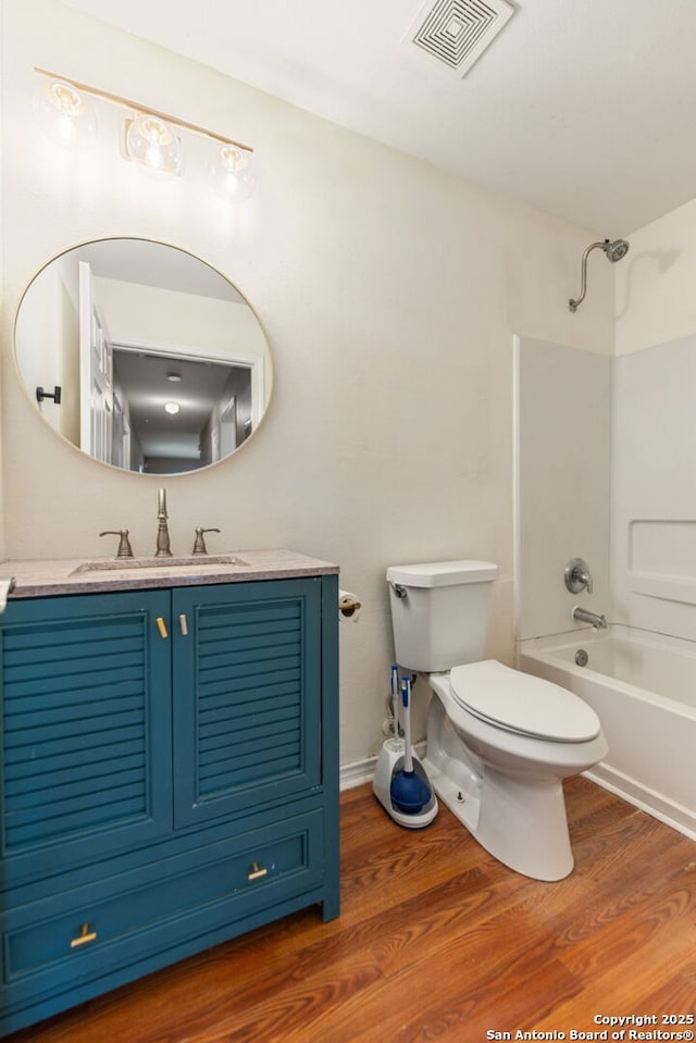 full bath with vanity, toilet, bathing tub / shower combination, wood finished floors, and visible vents