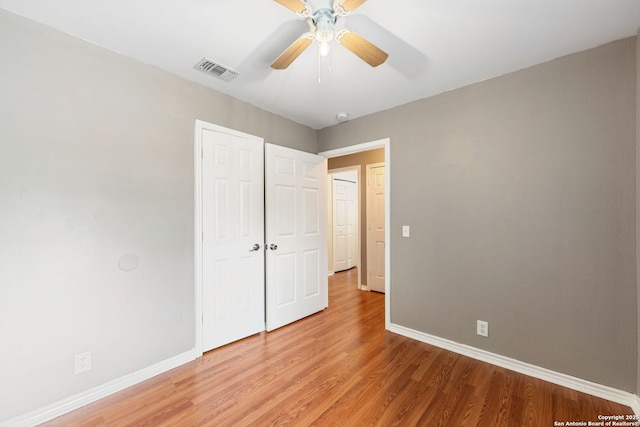 unfurnished bedroom with ceiling fan, visible vents, baseboards, a closet, and light wood finished floors