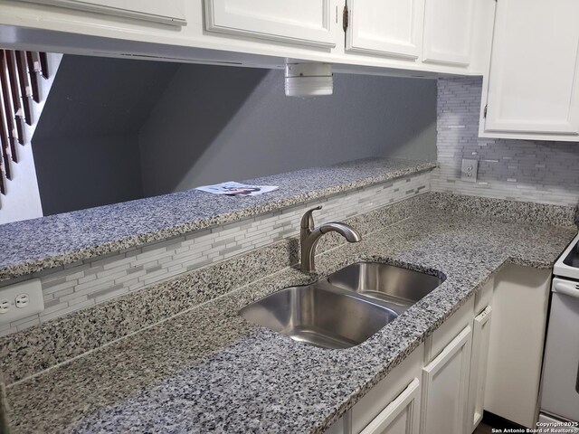 4107 Medical Unit 1204, San Antonio, TX 78229 - interior details featuring white cabinetry, white electric range oven, decorative backsplash, and a sink