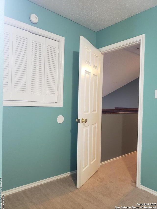 4107 Medical Unit 1204, San Antonio, TX 78229 - unfurnished bedroom featuring baseboards, a closet, carpet flooring, and lofted ceiling