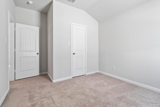 unfurnished bedroom with baseboards, carpet flooring, and lofted ceiling