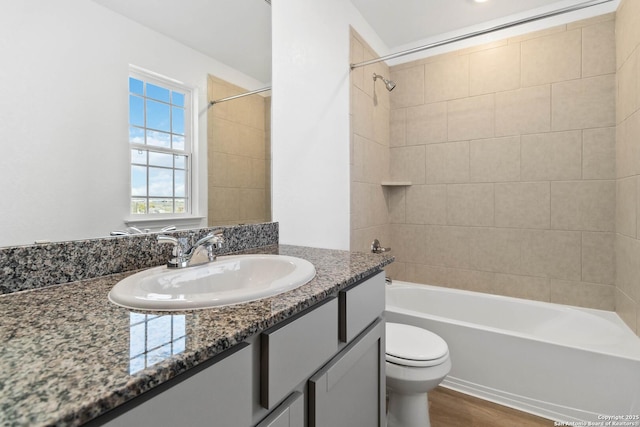 bathroom featuring toilet, shower / bath combination, wood finished floors, and vanity
