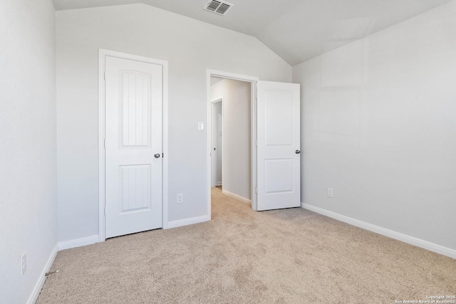 unfurnished bedroom with baseboards, carpet, lofted ceiling, and visible vents