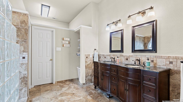 bathroom with double vanity, a sink, and tile walls