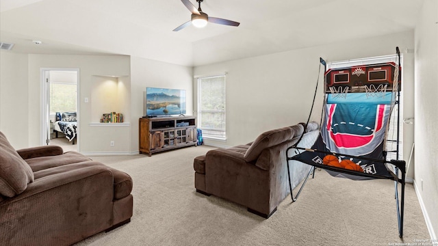 carpeted living room featuring ceiling fan, visible vents, baseboards, and lofted ceiling