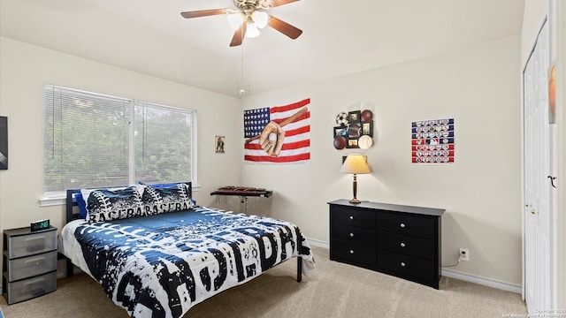 carpeted bedroom with a ceiling fan and baseboards
