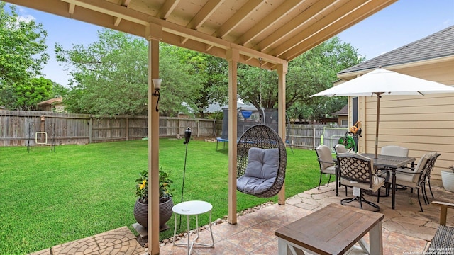 view of patio with outdoor dining area, a fenced backyard, and a trampoline