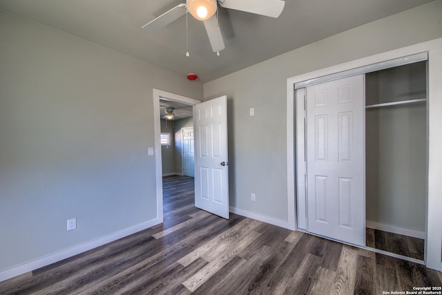 unfurnished bedroom with baseboards, ceiling fan, dark wood-style floors, and a closet