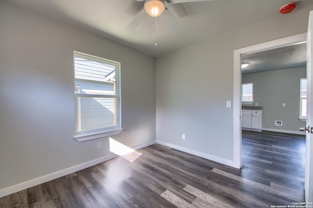 unfurnished room featuring ceiling fan, baseboards, and dark wood-type flooring