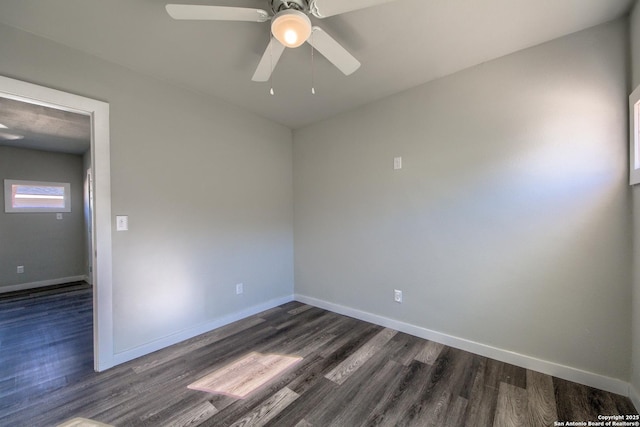 unfurnished room with baseboards, ceiling fan, and dark wood-type flooring