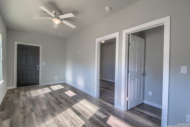 empty room with a ceiling fan, baseboards, and wood finished floors