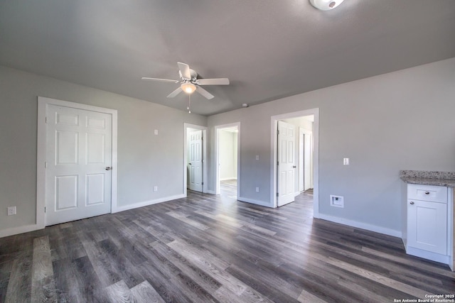 unfurnished bedroom with baseboards and dark wood-style floors