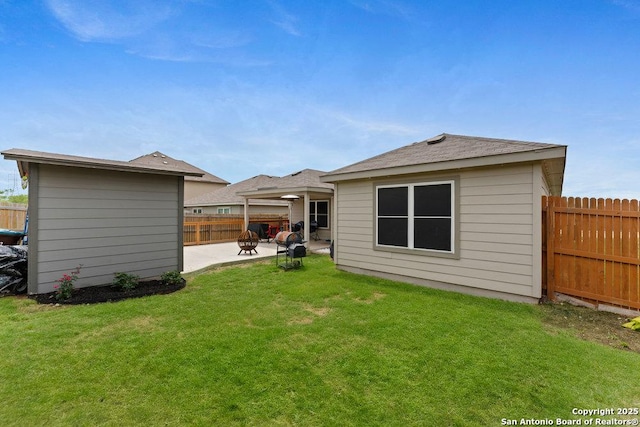 rear view of house with a lawn, a fenced backyard, and a patio area