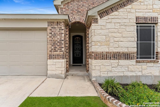 property entrance featuring an attached garage, brick siding, and stone siding
