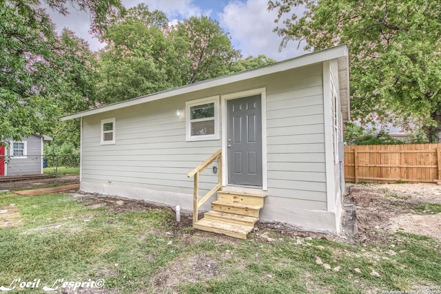 view of outbuilding featuring fence and entry steps