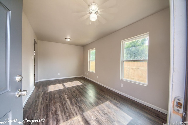 unfurnished room featuring baseboards, ceiling fan, and dark wood-style flooring