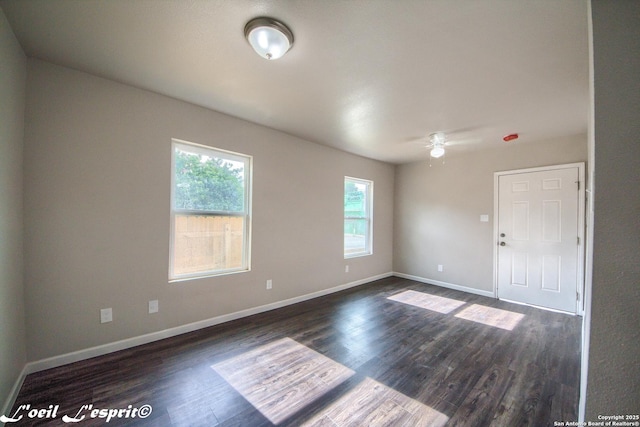 unfurnished room with baseboards, dark wood finished floors, and ceiling fan