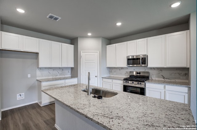 kitchen with visible vents, a sink, baseboards, dark wood-style floors, and stainless steel appliances