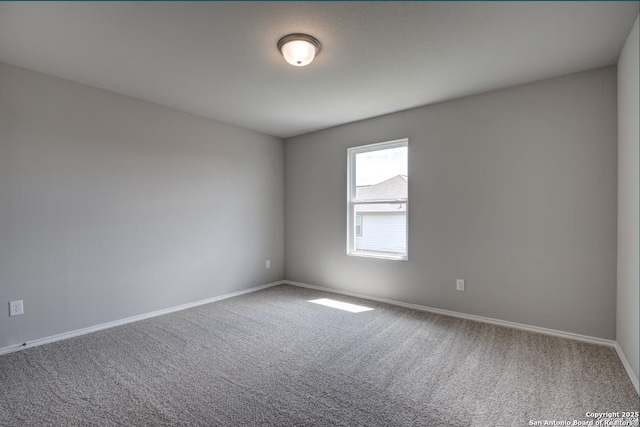 carpeted spare room featuring baseboards