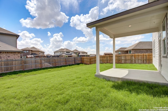 view of yard featuring a fenced backyard, a patio area, and a residential view