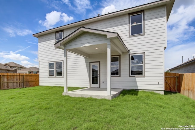 rear view of property featuring a lawn, a fenced backyard, and a patio area