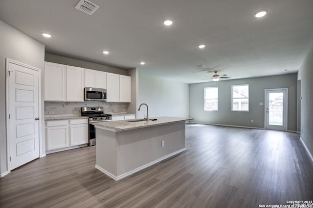 kitchen with ceiling fan, a sink, stainless steel appliances, open floor plan, and visible vents